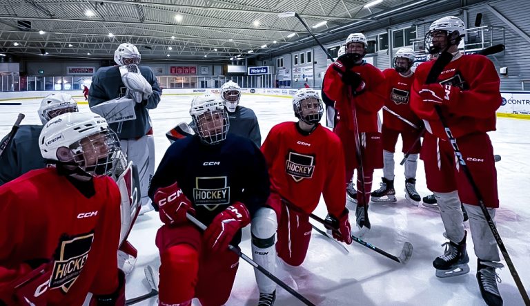 Hockeylag som sitter på isen i ishall med utrustning.