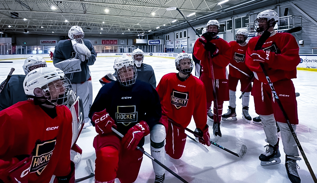 Hockeylag som sitter på isen i ishall med utrustning.